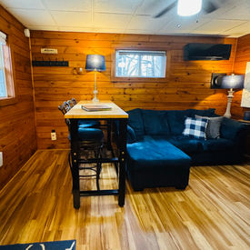 Multi use furnishings in a cozy cabin at Babbling Brook Cottages. Husky adjustable workbench used as high top dining table.
