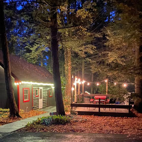 Bear Claw Cabin has exterior lighting and bistro lighting around its wood deck.