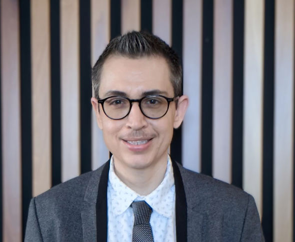 Coach Adam in a Grey Suit with a Striped Background