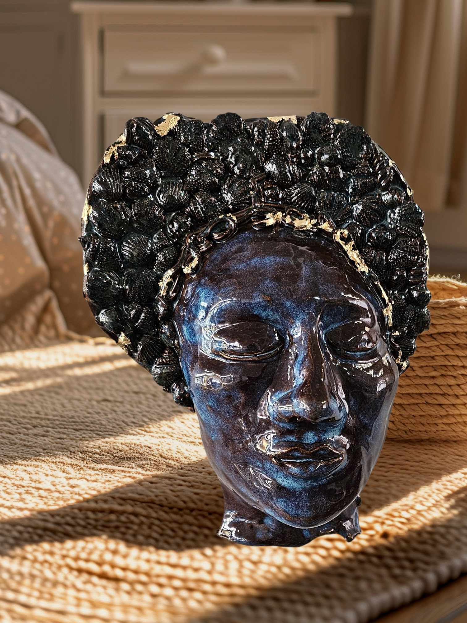 Handcrafted ceramic face sculpture with textured shell-inspired hair detail and deep blue glaze
