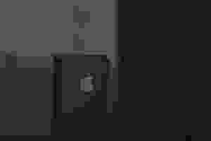 A black iPod is pictured on a black surface.