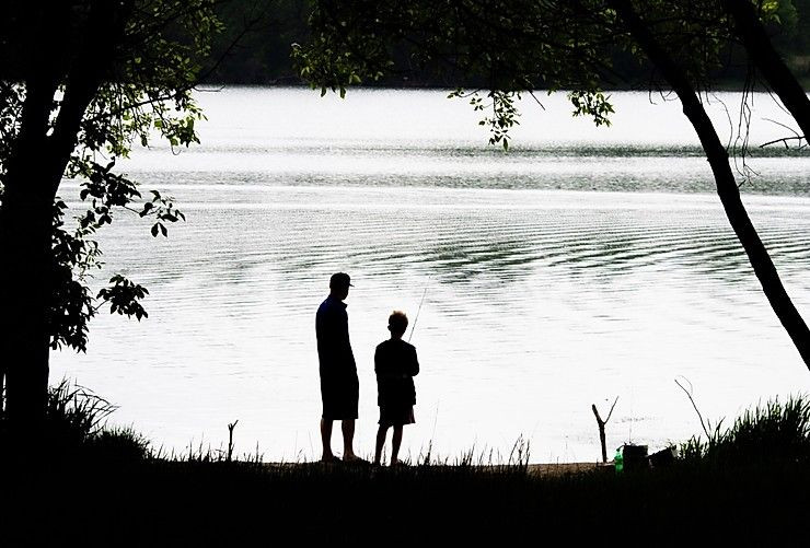 A dad and his child looking out at the lake.