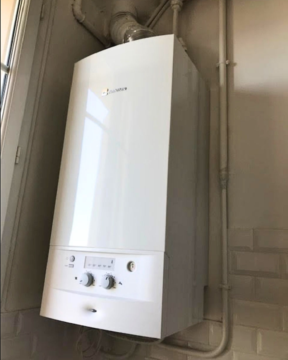 Chaudière murale individuelle récente installée dans un logement à Nice, avec tableau de commande simple et tuyauterie apparente.