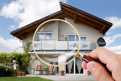 Person Hand With Magnifying Glass Over Luxury House.jpg