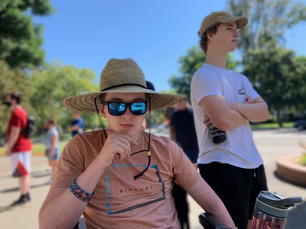 Jonny hanging out in the shade with sun hat and shades