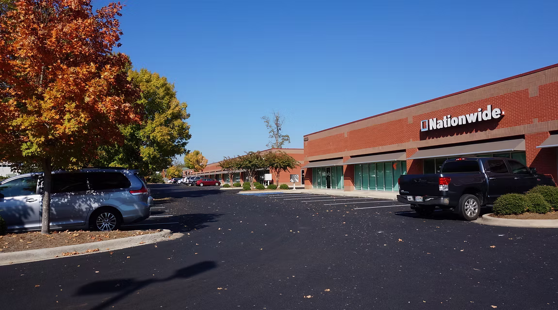 Meadow Lake Business Park exterior with Nationwide storefront, brick office building, parking lot, and autumn landscaping