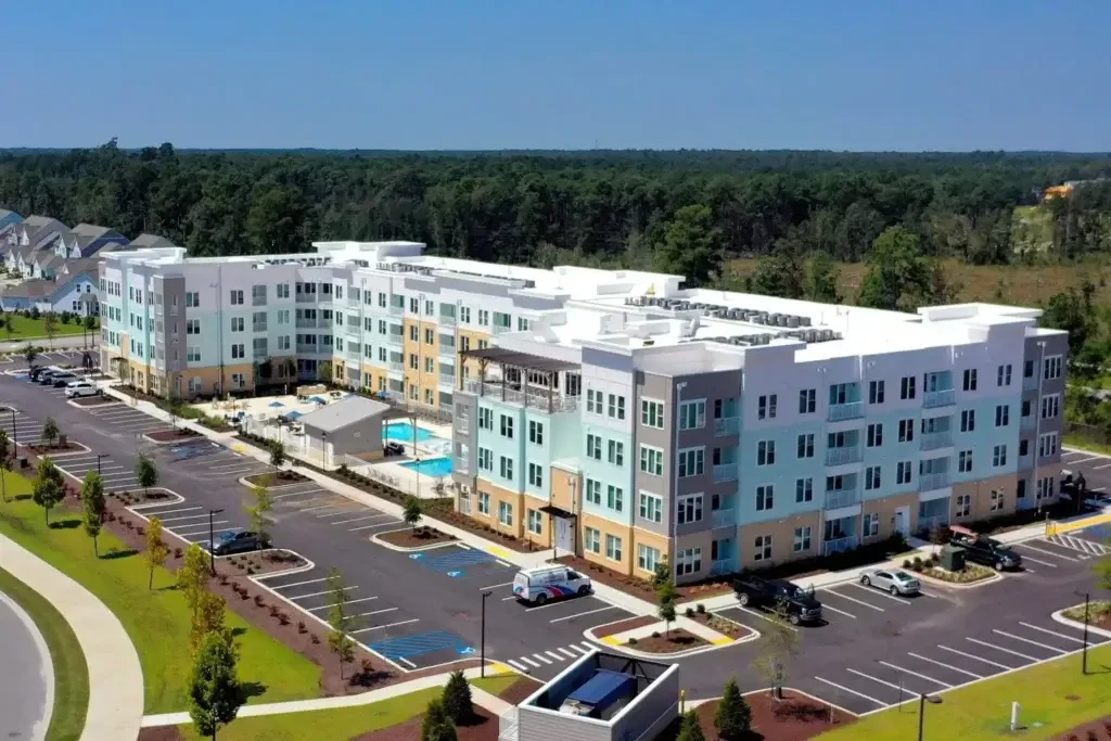 The Landing at Coventry aerial exterior view with apartment buildings, parking areas, pool courtyard, and wooded surroundings