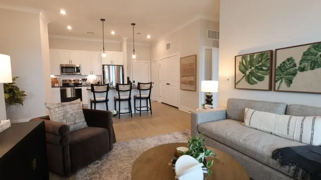 The Landing at Coventry apartment living area with open kitchen, island seating, modern furniture, and wood-style flooring