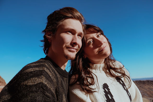 Red-Rocks-Amphitheatre-Couple-Sitting-Golden-Sunlight-Denver-Colorado-Skyline-Background