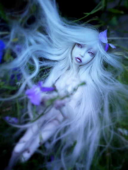 ethereal fairy art doll, sitting with flowers in a fairy tale like surroundings