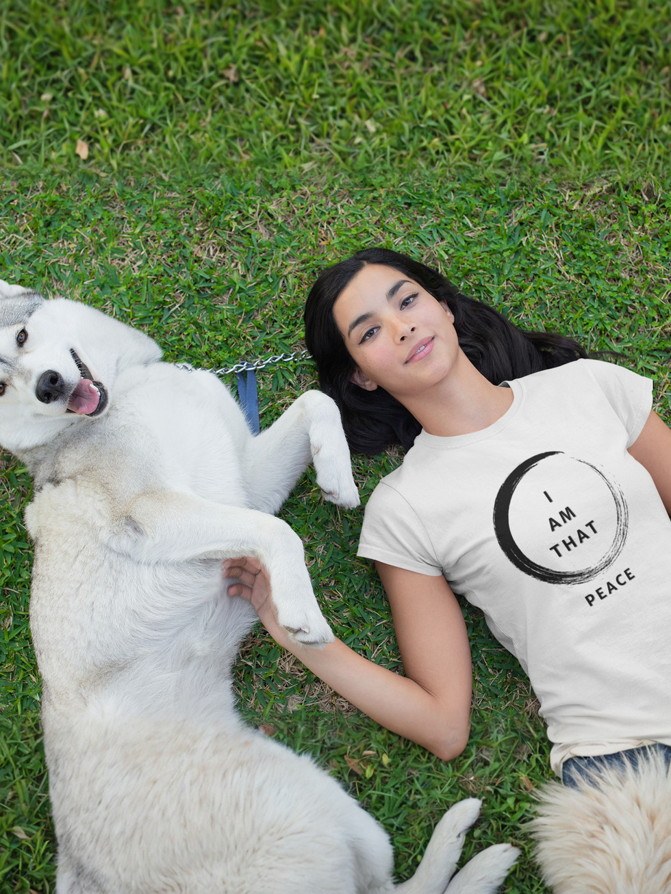 Woman in 'SO HAM' t-shirt lies on grass with husky dog