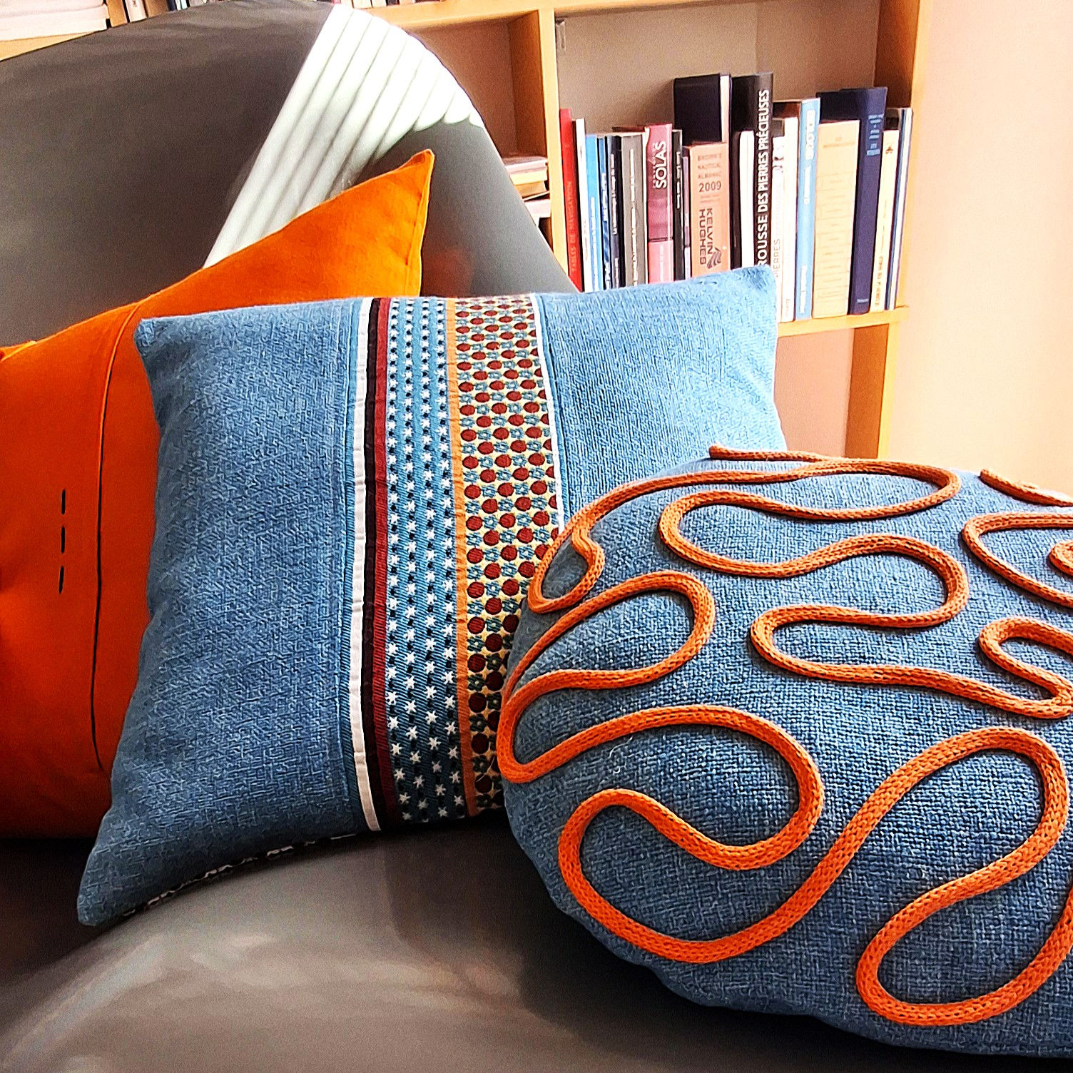 Gàli 2 Coussin de forme galet avec volutes de coton en couleur contrastée. Dimensions 43 cm x 35 cm