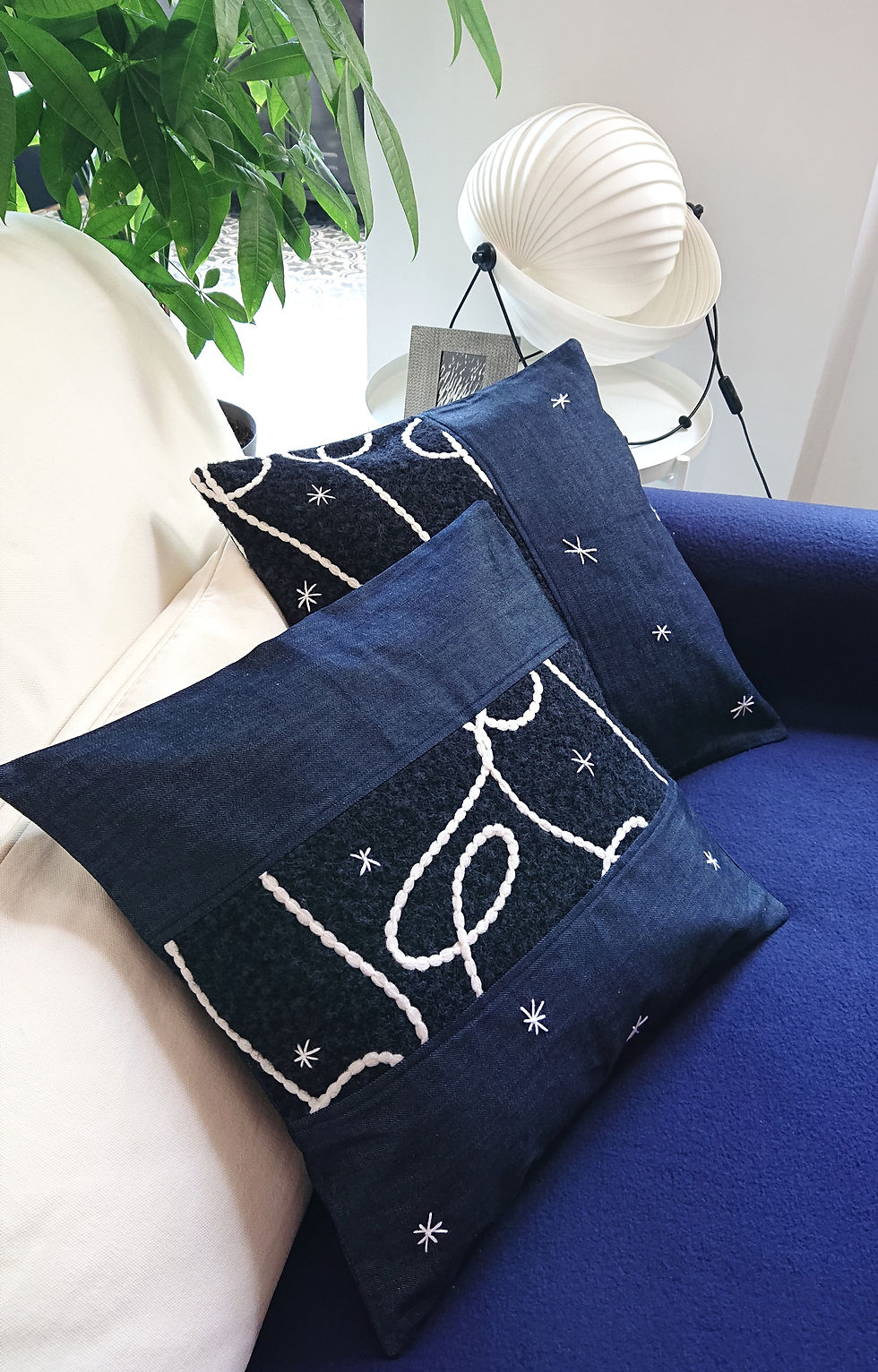 CIELO Housse de coussin Déco en jean brut et polaire, photographiée avec un autre modèle sur un canapé
