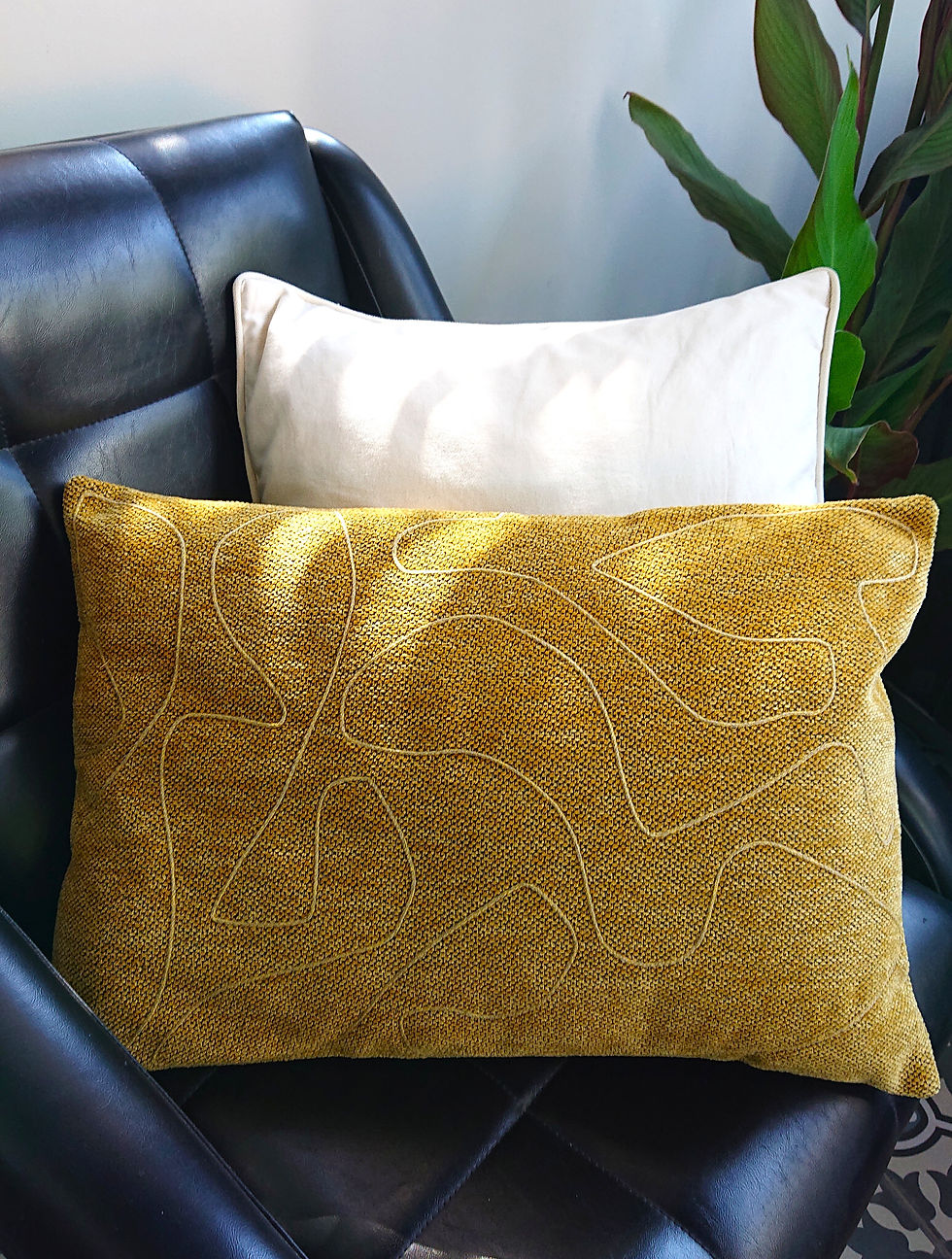 CLORO Housse de coussin ARTY rectangulaire, présentée sur un fauteuil rétro.