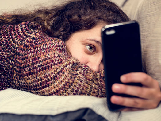 Young girl looking blankly on her smartphone
