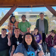 Members and staff from Lexington Services DTA gather under a pergola during a community garden outing in Show Low.