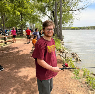 Member fishing along the shoreline at Lazy Oaks Resort during a special needs community event