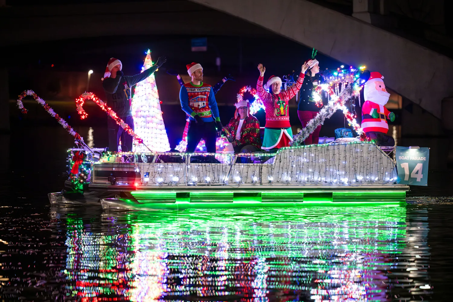Slow moving boats covered in Christmas lights on Arizona waterfront