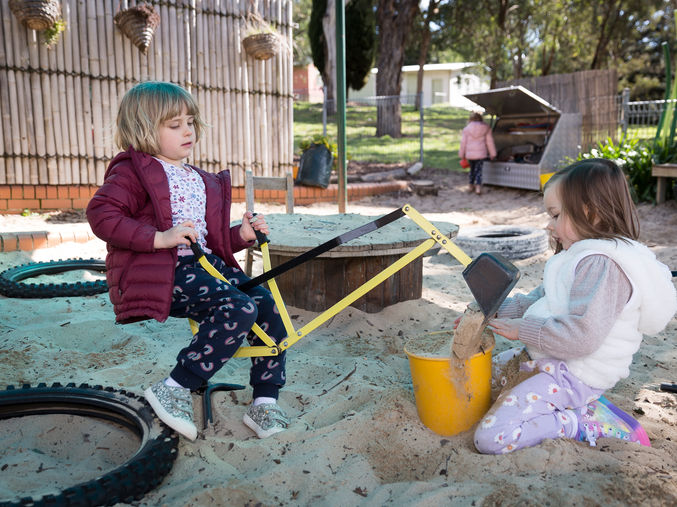 Preschool children digging a sandpit
