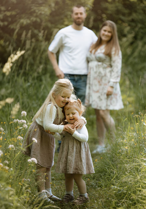 Stemningsfullt bilde av søstre under en familiefoto tatt i naturen