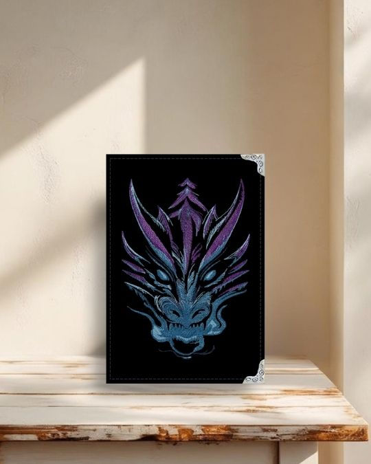 Capa para Kindle em tecido preto com bordado detalhado de cabeça de dragão e acabamento artesanal.