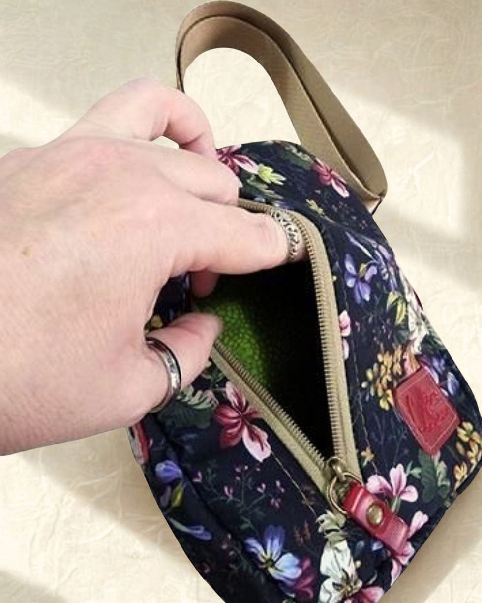 Miniatura: Mão abrindo o zíper superior da shoulder bag, mostrando o interior forrado