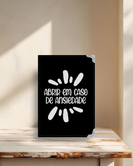 Capa para Kindle em tecido preto com a frase bordada Abrir em Caso de Ansiedade e acabamento artesanal.