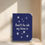 Miniatura: Capa de Kindle azul escuro bordada com estrelas prateadas e frase “Don’t touch my Kindle”; elástico azul escuro