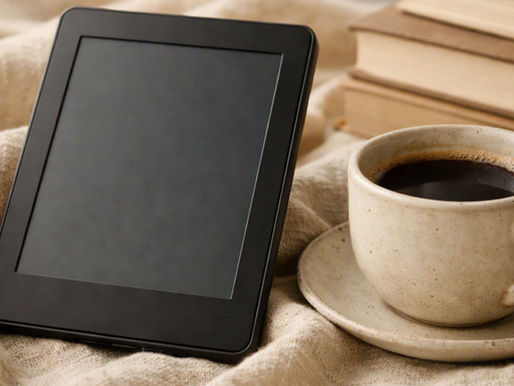 E-reader com tela apagada sobre manta de algodão bege, ao lado de xícara de café e livros empilhados
