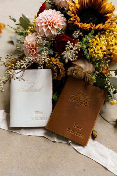 Close-up of a beautiful floral arrangement with wedding rings delicately placed among the blooms, showcasing the elegance of Blossom & Bloom Floristry’s wedding flowers.