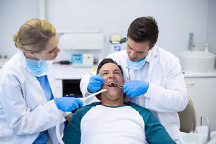 dentists-examining-male-patient-with-tools.jpg