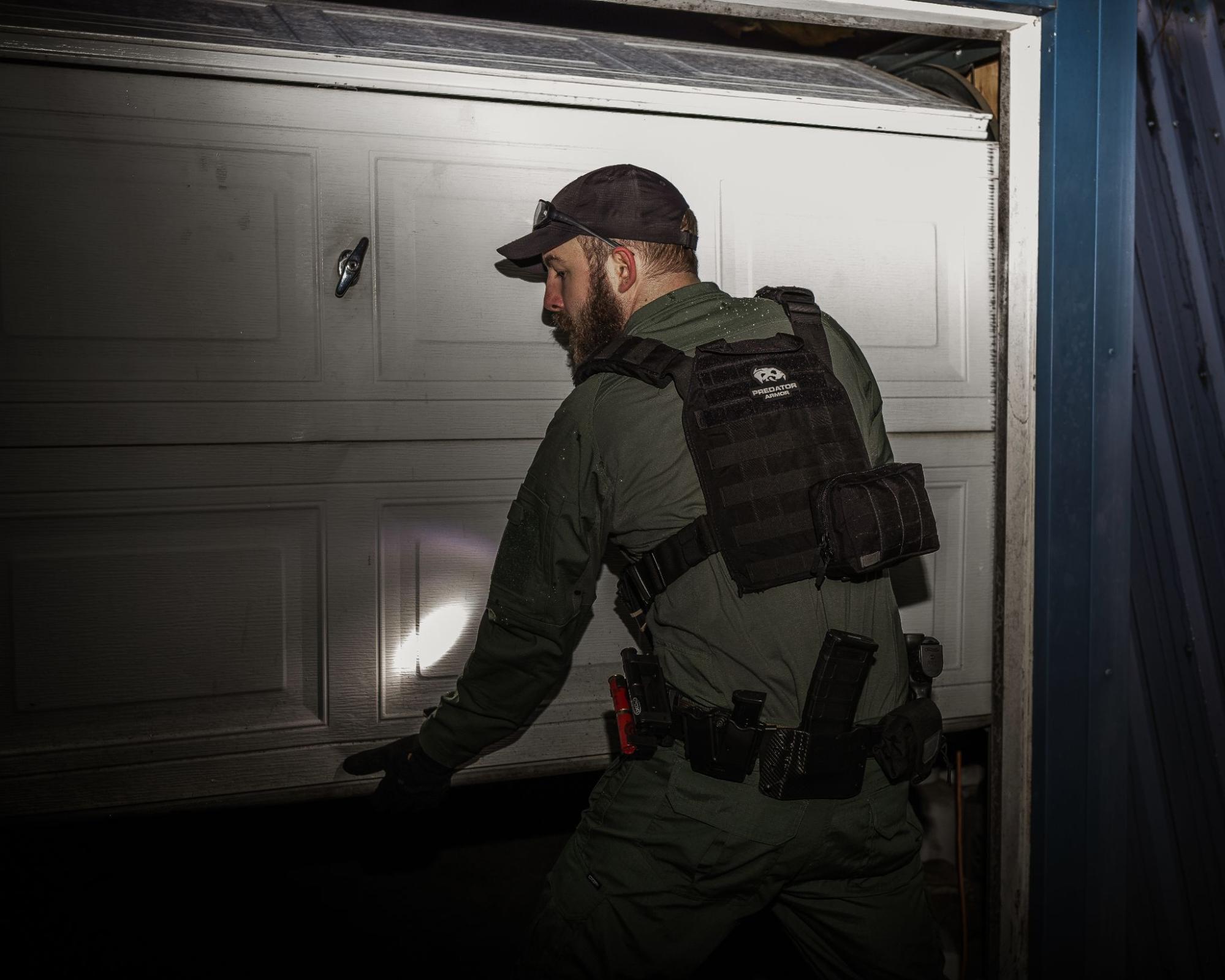 Man in tactical gear and body armor with a flashlight