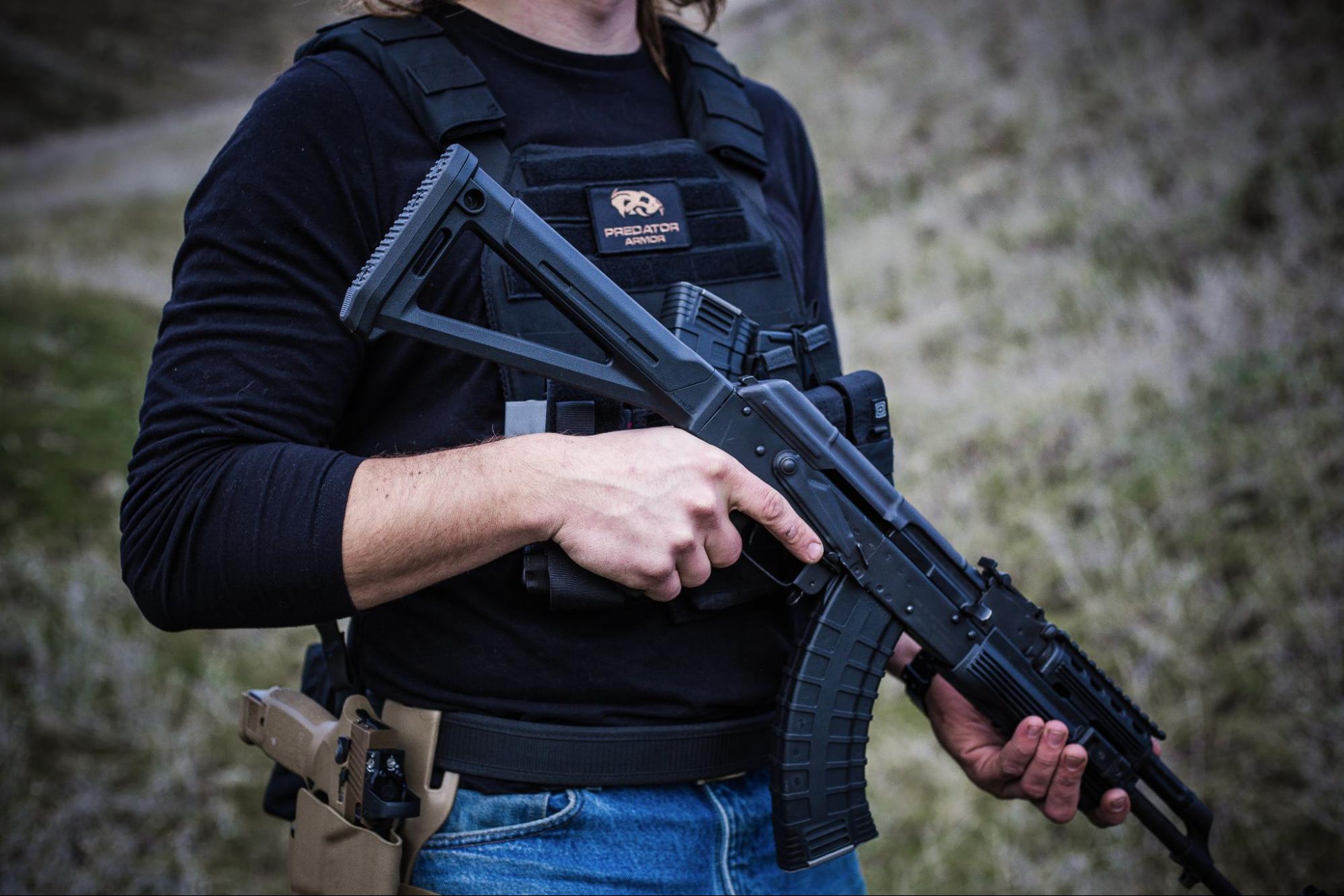 Man holding an AK47 with body armor