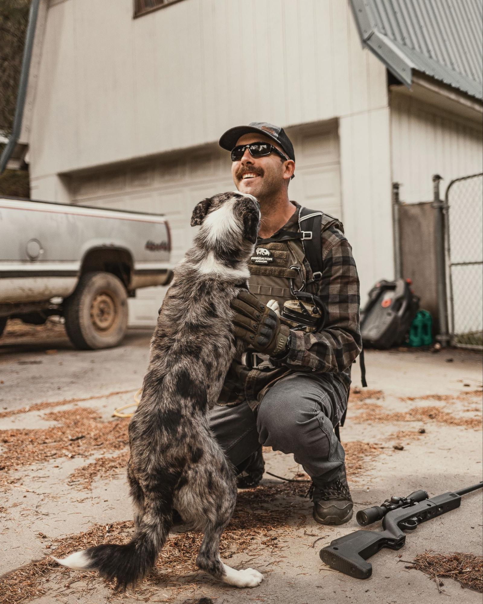 Man wearing tactical gear with dog