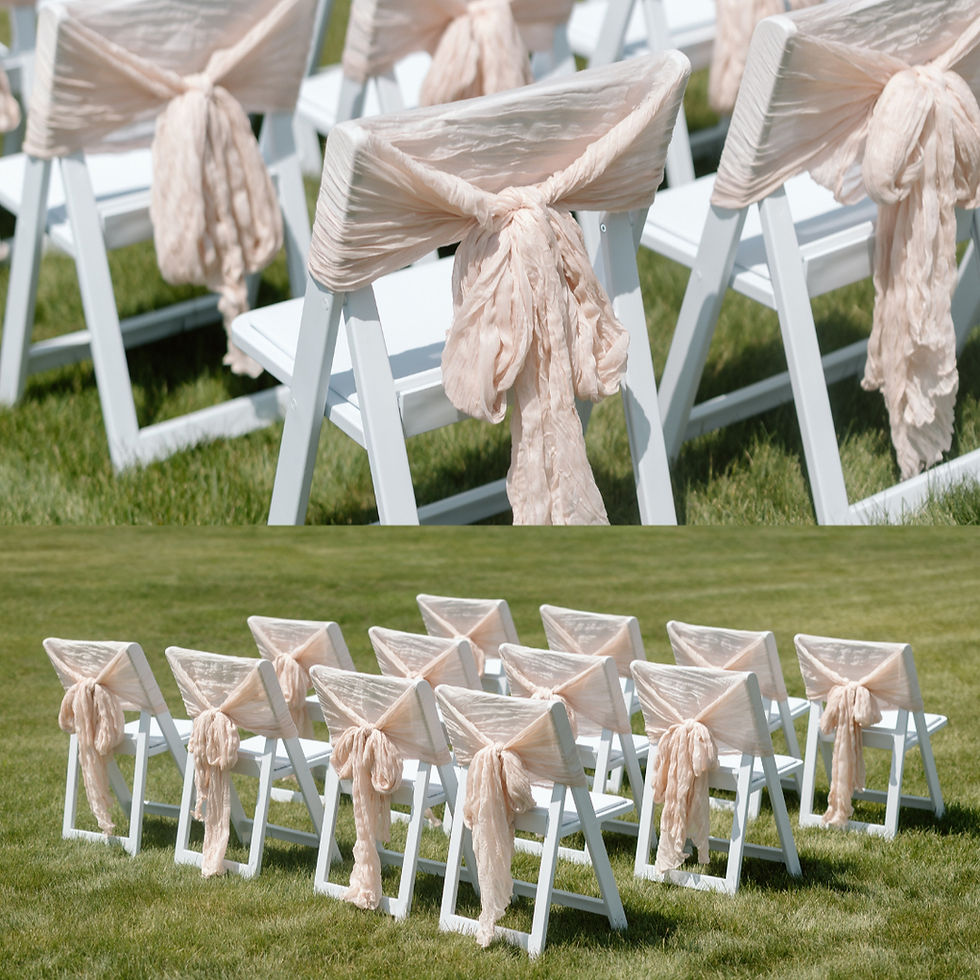 Thumbnail: White folding chairs decorated with blush cheesecloth chair sashes for an outdoor wedding ceremony setup in Lloydminster.
