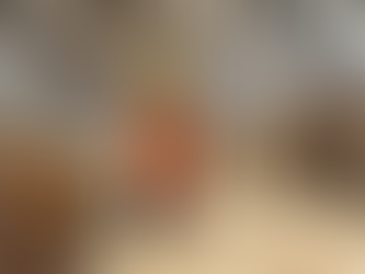 Pallet manufacturing facility worker with a wooden plank, surrounded by stacks of assembled pallets