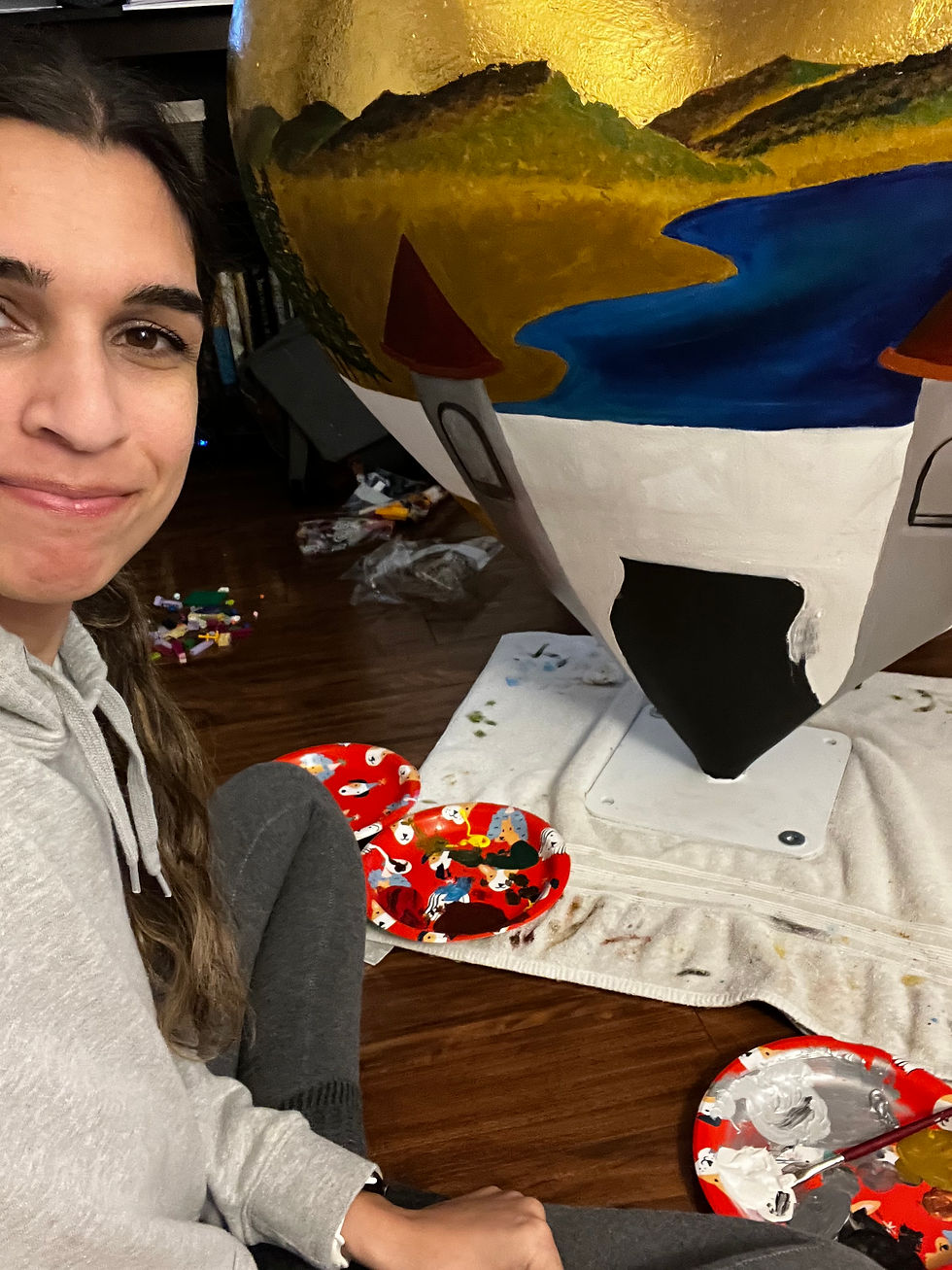 girl painting on heart sculpture
