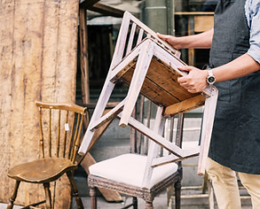 Midsection of man holding chair while st