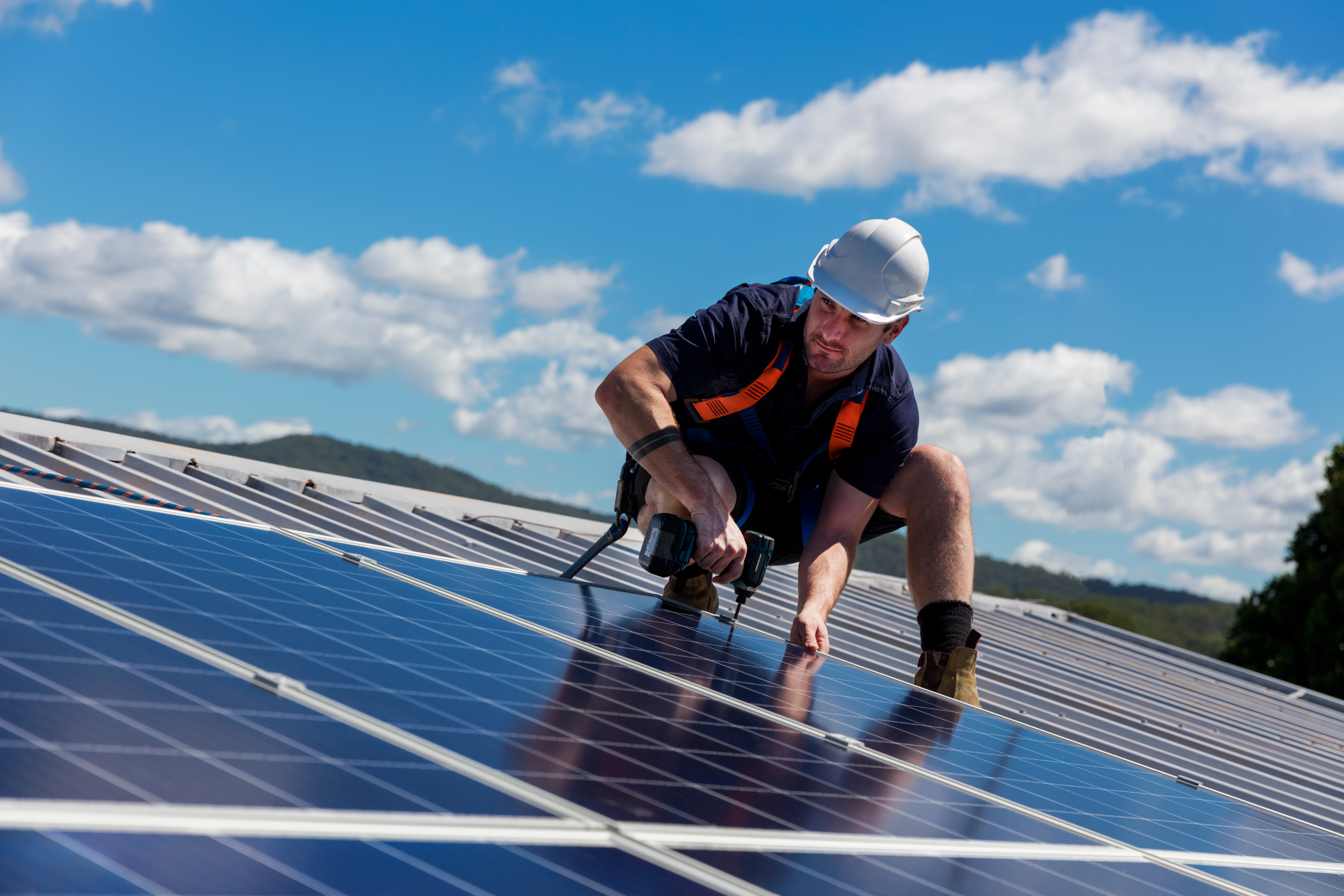 Technician fitting solar panels on a roof