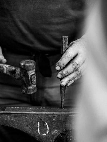 Man holding a hammer and a chisel in black and white