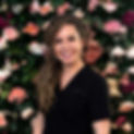 Smiling woman against vibrant floral backdrop.jpg