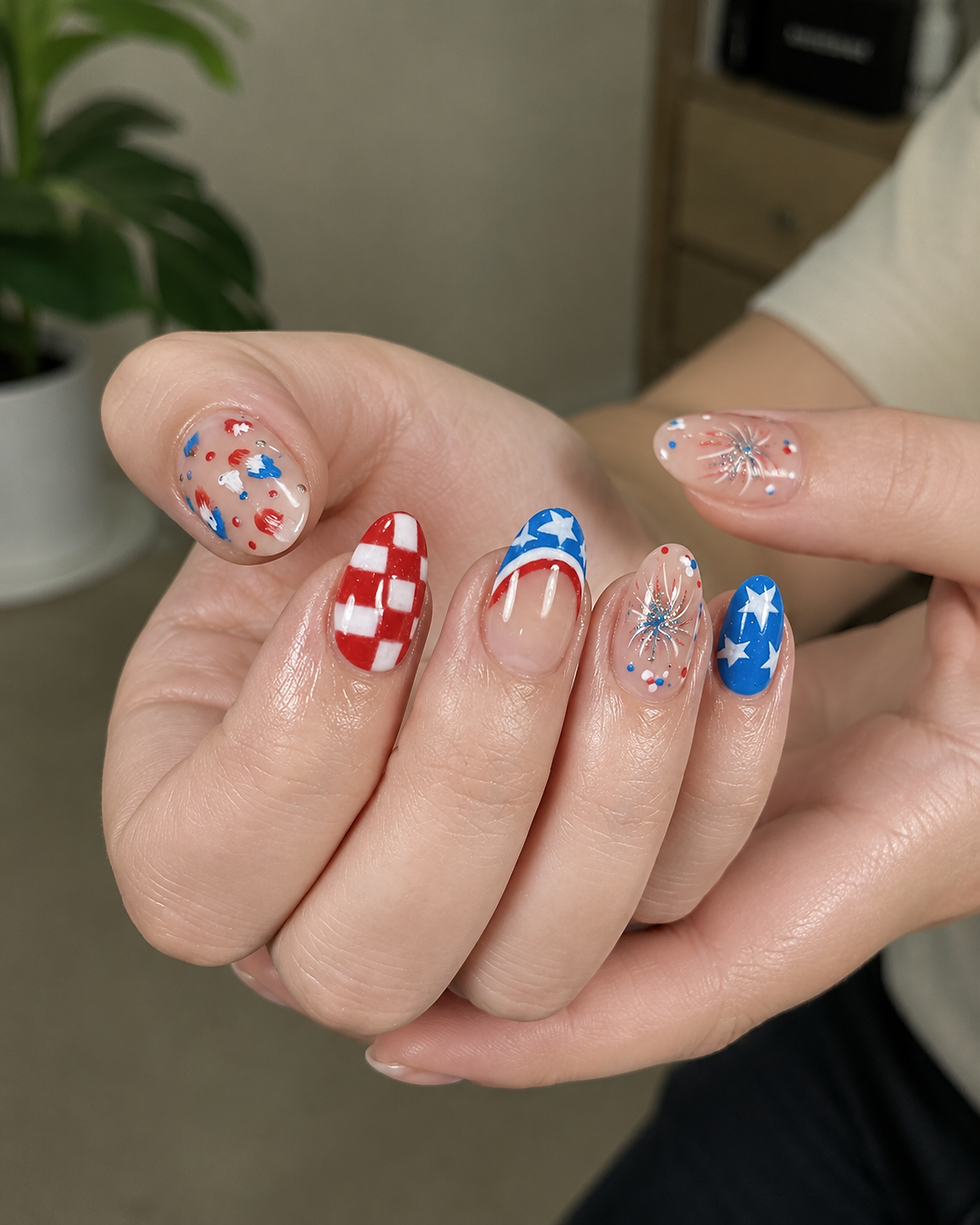 Close-up of hands with glossy red, white, and blue patriotic nail art, including stars and fireworks, indoors near a plant.