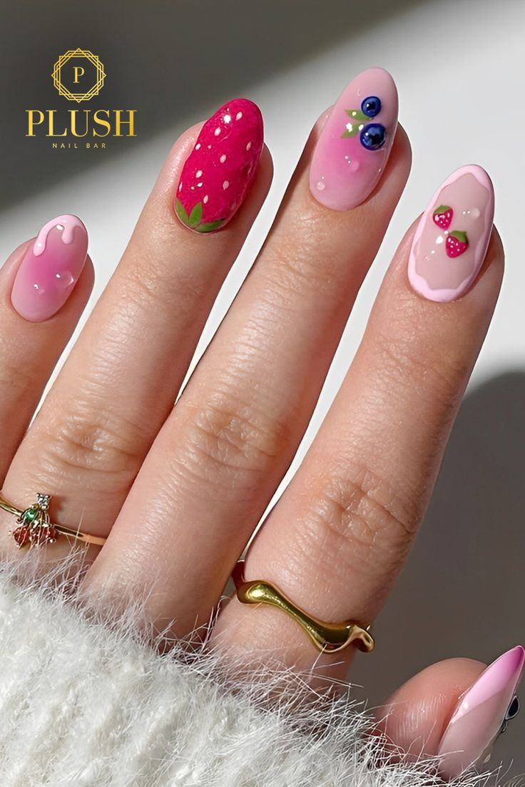 Fruit-inspired pink nails with strawberry, blueberry, and icing designs, combining ombré pink nails, cute pink nails, pink nails with design, pink gel nails, pink and white nails, pink nail art, and natural pink nails.