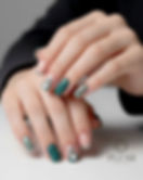 Chic dark green Christmas nails with knitted sweater texture, silver glitter accents, and mini Santa hat art by Plush Nail Bar