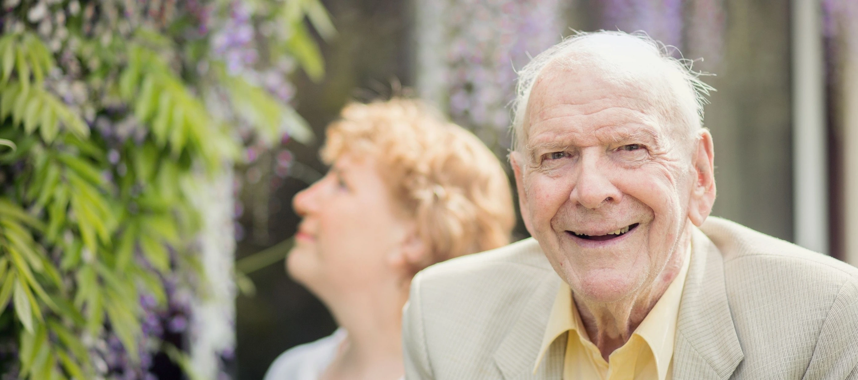 Smiling elderly gentleman in the garden with his home carer