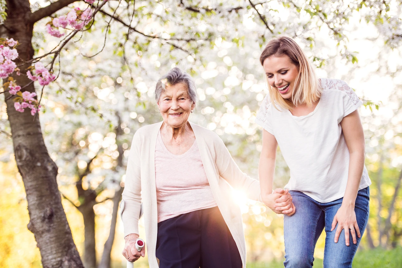  Smiling elderly Live In Care clients outside holding hands