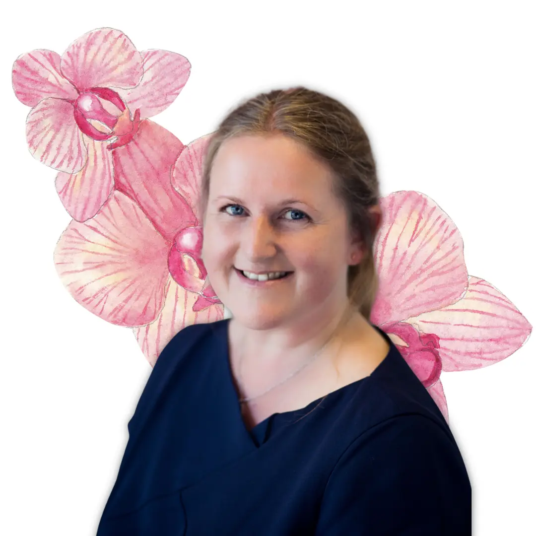 Lady in navy dress smiling in front of pink flowers working as companion care consultant