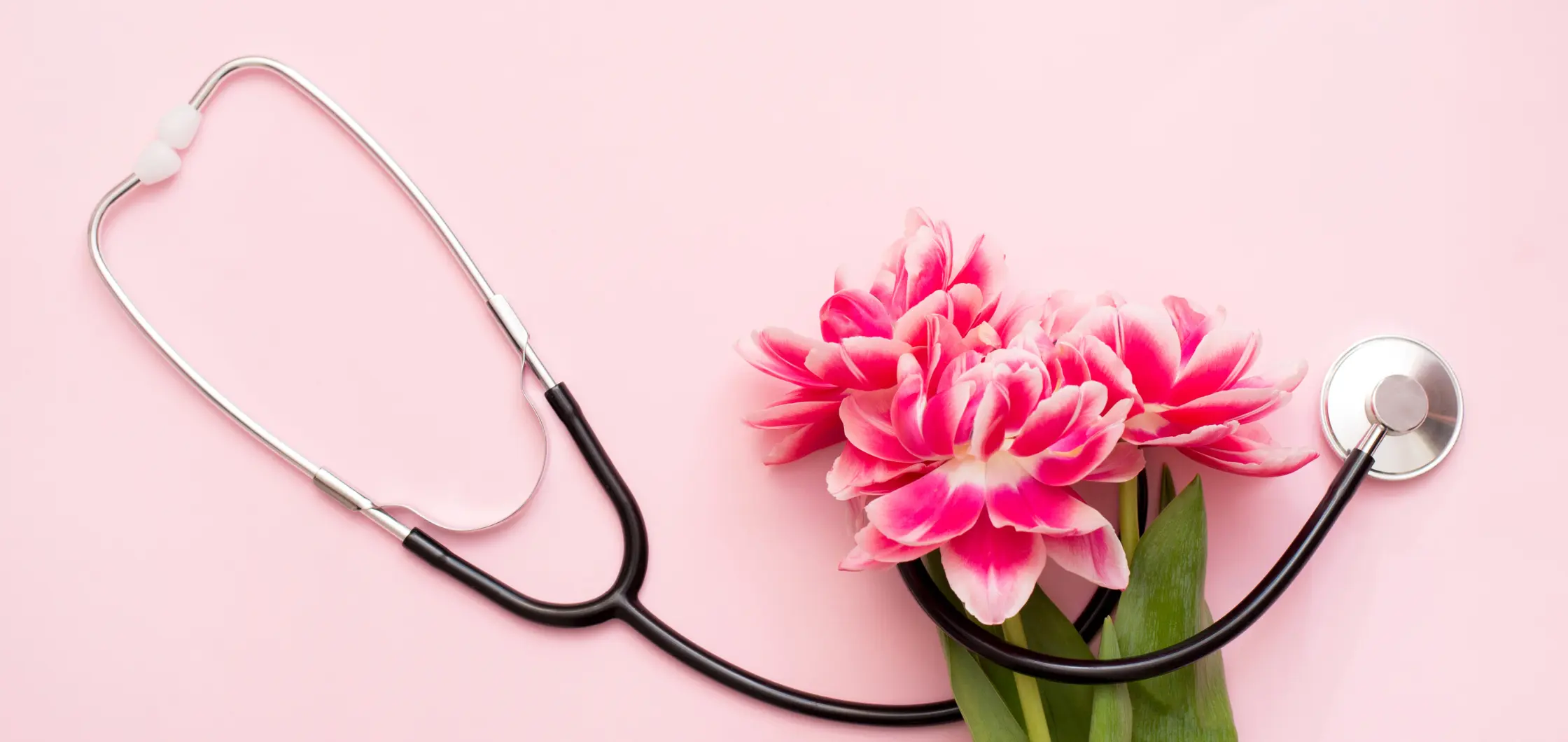 Pink flowers on pink background with a Live In Care giver stethoscope
