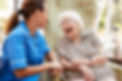 Senior Woman Sitting In Chair And Talking With Nurse In Retirement Home.jpg