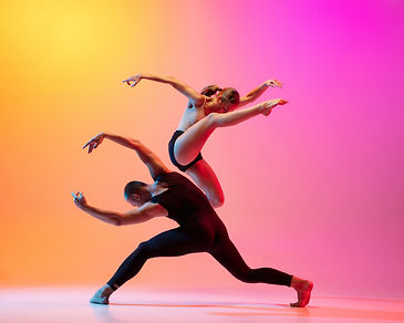 Two dancers, stylish sportive couple dancing contemporary dance on colorful gradient yello